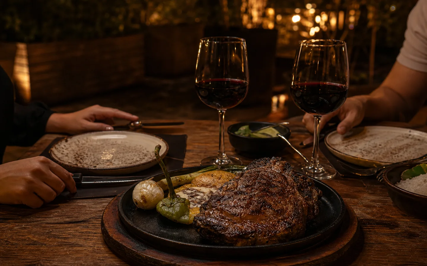 Cena para dos con corte al carbón y copas de vino en la terraza
