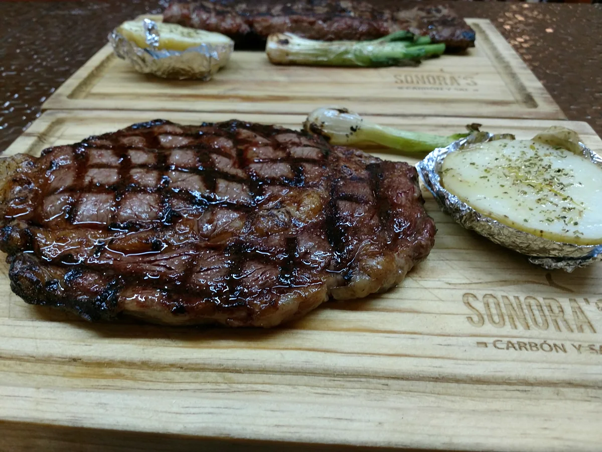Ribeye al carbón servido en tabla en Sonora's Carbón y Sal